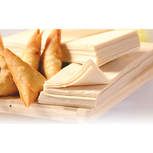 Stacked samosa patti sheets beside freshly fried samosas